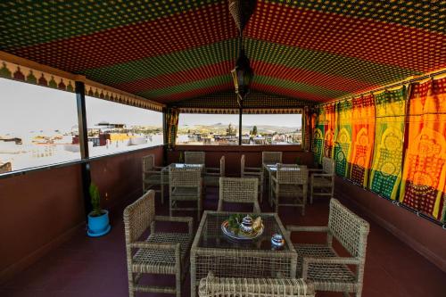 a dining room with tables and chairs and windows at Dar Layali Fez in Fès