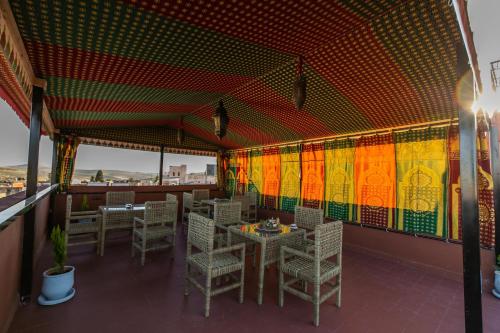 a restaurant with tables and chairs and colorful walls at Dar Layali Fez in Fès