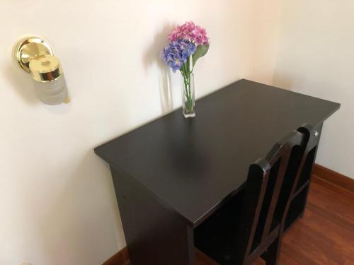 a black table with a vase of flowers on it at Hotel de Turistas Abancay in Abancay