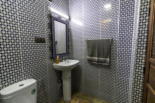 a bathroom with a sink and a toilet and a mirror at Dar Layali Fez in Fès