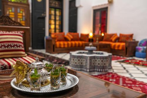 Dar Layali Fez في فاس: غرفة معيشة مع طاولة عليها أكواب