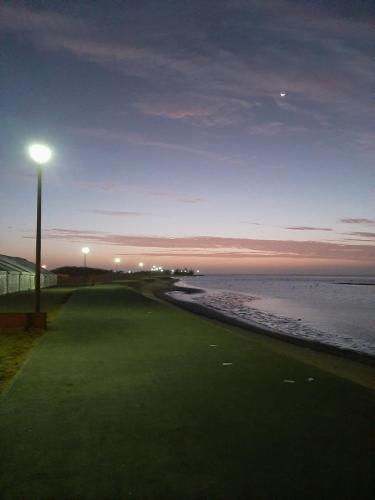 un campo de golf junto al océano con luz de la calle en Elilo Bed and breakfast en Walvis Bay