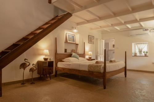 a bedroom with a large bed and a staircase at The Island Sanctuary Rock Pool Villa in Chorao