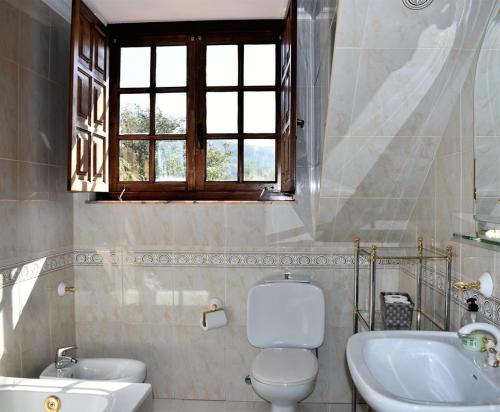 オレニャにあるCasa Cameliaのバスルーム(トイレ、洗面台付)、窓が備わります。