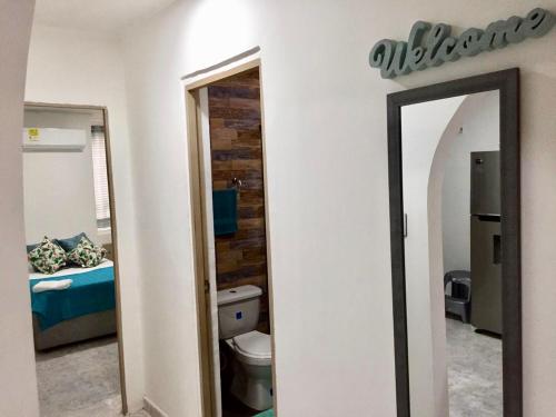 Apartamento rodadero playa y diversion في سانتا مارتا: مرآة في غرفة مع سرير وحمام