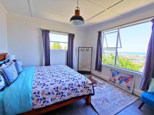 um quarto com uma cama e uma grande janela em 180 degrees sea view 180度全海景房 em Oamaru
