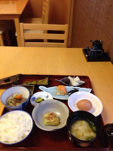 a tray of food on a table with bowls of food at Ryokan Seifuso in Ōmuta