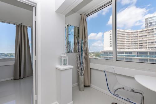 een witte kamer met een stoel en een raam bij Ocean Beach Condo 3BR On the Sand 911 in Fort Lauderdale