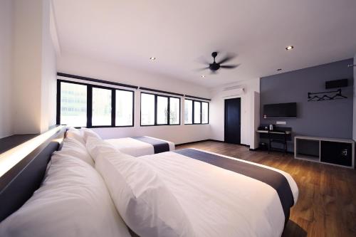 a large white bedroom with a large bed and a couch at ARENA Boutique Hotel Kuala Terengganu in Kuala Terengganu