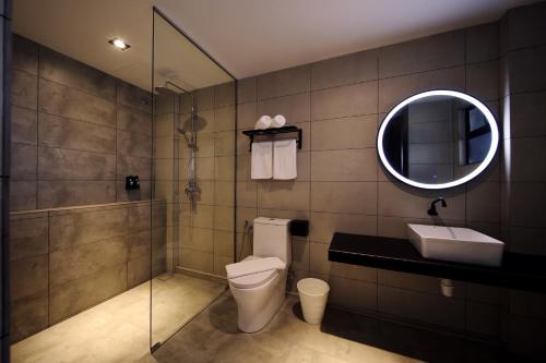 a bathroom with a toilet and a sink and a mirror at ARENA Boutique Hotel Kuala Terengganu in Kuala Terengganu