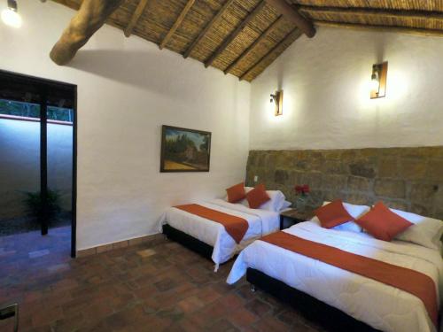 a bedroom with two beds in a room at Hotel Casas de Campo El Ciruelo in San Gil