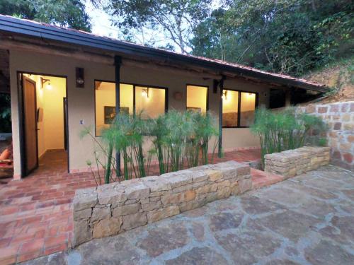 a house with a stone wall in front of it at Hotel Casas de Campo El Ciruelo in San Gil