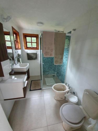 ein Badezimmer mit Toilette, Waschbecken und Dusche in der Unterkunft Casa pé na areia em Toque Toque in São Sebastião