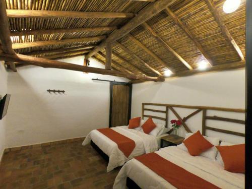 a bedroom with two beds in a room at Hotel Casas de Campo El Ciruelo in San Gil