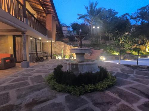 a fountain in the middle of a courtyard at night at Hotel Casas de Campo El Ciruelo in San Gil