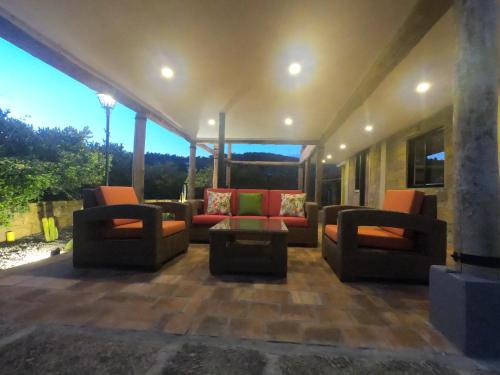 a living room with couches and chairs on a patio at Hotel Casas de Campo El Ciruelo in San Gil