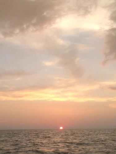 a sunset over the ocean with the sun in the distance at Som PalmGarden in Ko Lanta