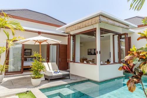 
a hotel room with a pool and a balcony at Canang Villas Bingin in Uluwatu
