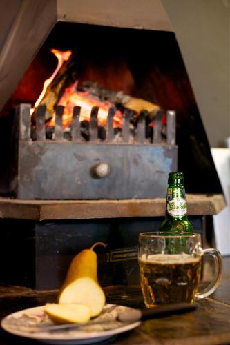 a bottle of beer and a plate of fruit next to a grill at Boord Guest House in Stellenbosch