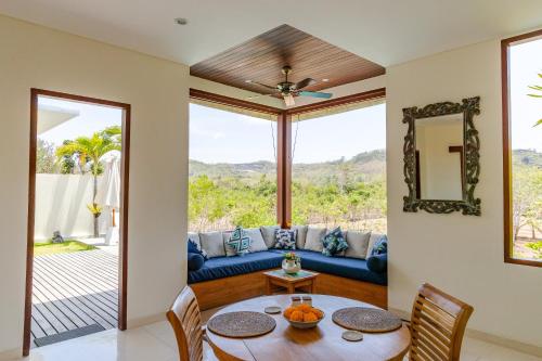 a living room with a blue couch and a table at Canang Villas Bingin in Uluwatu