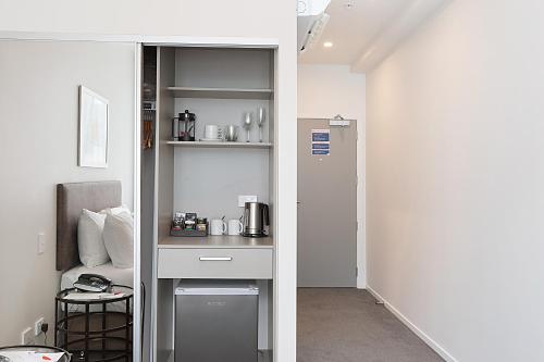 a room with a kitchen with a counter and a pantry at Ramada Suites By Wyndham Victoria Street West in Auckland