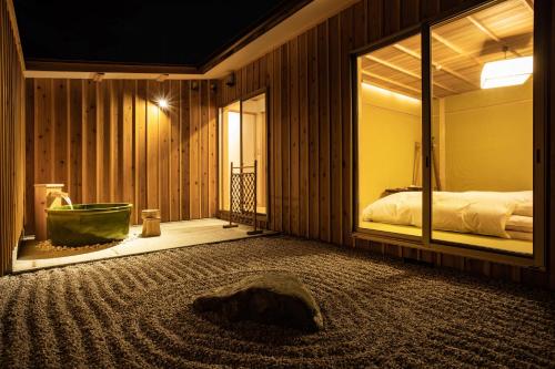 a bedroom with a bed and a window with a tub at 宿坊 観音院 Temple Hotel Kannonin in Kiryu