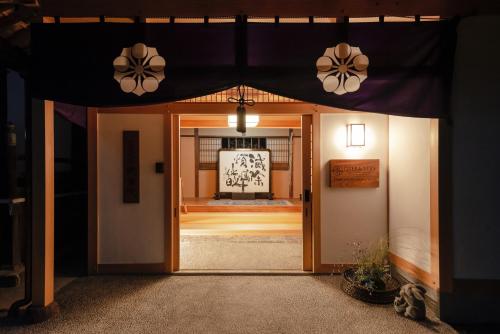 una entrada a una casa con techo negro en 宿坊 観音院 Temple Hotel Kannonin, en Kiryu