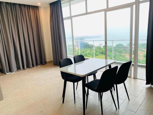 einen Tisch und Stühle in einem Zimmer mit einem großen Fenster in der Unterkunft The Hill Residence in Sihanoukville