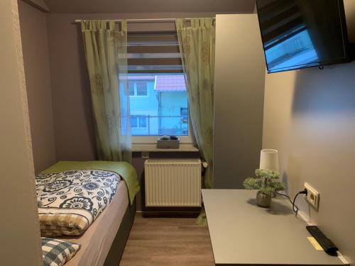 a small bedroom with a bed and a window at landpension-dette in Berlingerode