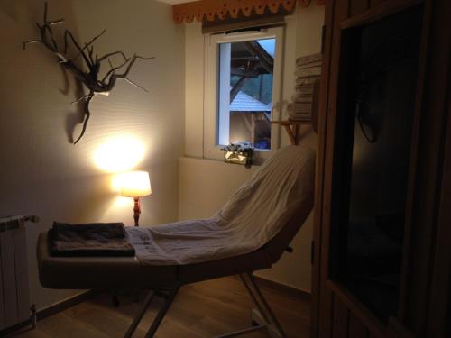 a chair in a room with a lamp and a window at Maison La Devinière - sauna et spa compris accessibles toute l'année in Xonrupt-Longemer