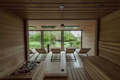 une chambre avec des chaises et un foyer extérieur dans une maison en bois dans l'établissement Káli Art Inn, à Köveskál