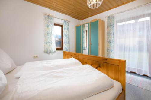 a bedroom with a white bed and a window at Zur Oma Margret in Flachau