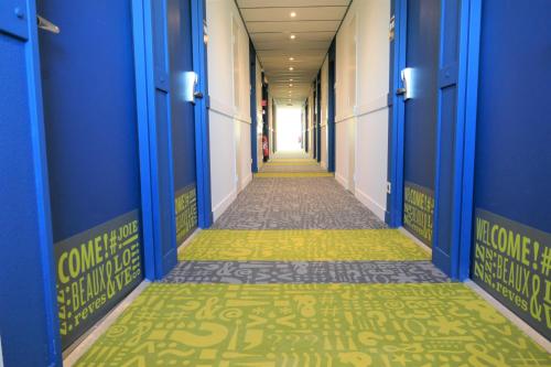 a corridor of a hospital hallway with blue and yellow floors at Ibis Budget Perigueux Boulazac in Boulazac