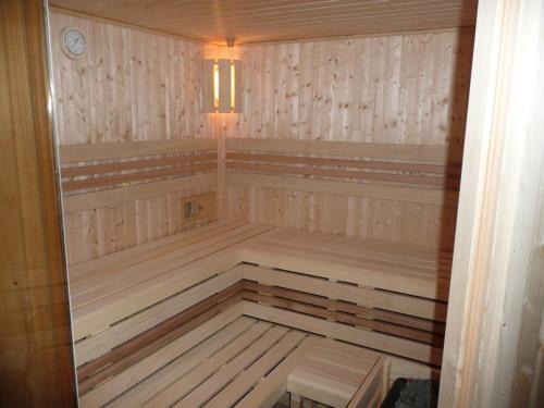 a sauna with wooden paneling and a light in it at Wellness Chata Rosnatka in Kvilda
