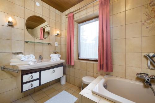 a bathroom with a tub and a sink and a toilet at Zur Oma Margret in Flachau