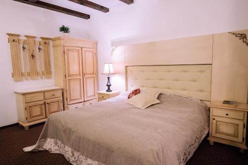 a bedroom with a large bed and wooden cabinets at Pensiunea Ghiocelul in Avrig