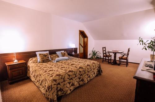 - une chambre avec un lit, une table et des chaises dans l'établissement Pensiunea Ghiocelul, à Avrig