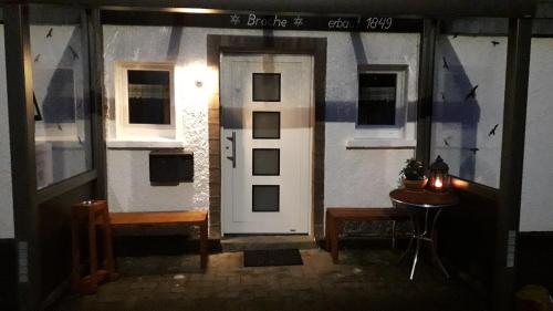 a front door of a house with a table in front at Ferienhaus Broche in Hilchenbach