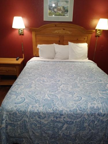 a large bed in a hotel room with two lamps at Econo Inn in Anchorage