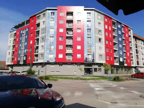 un gran edificio de apartamentos de color rojo blanco y azul en Jacuzzi Room, en Subotica