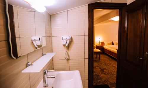 a bathroom with a sink and a phone on the wall at Pensiunea Ghiocelul in Avrig