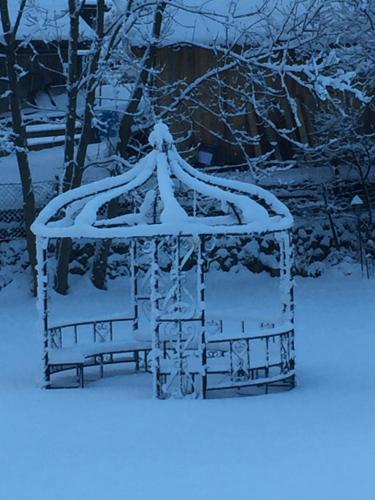 a gazebo covered in snow in a yard at Chalet am See in Nassereith