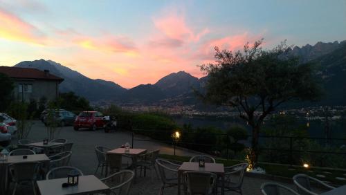 a group of tables and chairs with a view of the mountains at Hotel Ristorante Parco Belvedere in Pescate