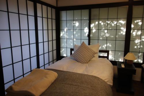 a bedroom with a bed and a window with lights at Yamaguchi House Annex, Private House with Onsen in Hakone