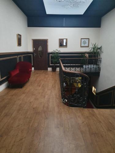 a living room with a red chair and wooden floors at Salon Boyer in Épernay