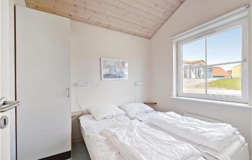 a white bedroom with a bed and a window at Marina Fiskens Feriepark in Gråsten