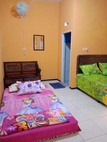1 dormitorio con 1 cama, 1 sofá y 1 globo en Homestay Andari, en Batu