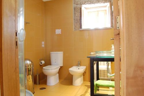 a bathroom with a toilet and a sink at Casa da Carriça - Serra da Estrela in Guarda
