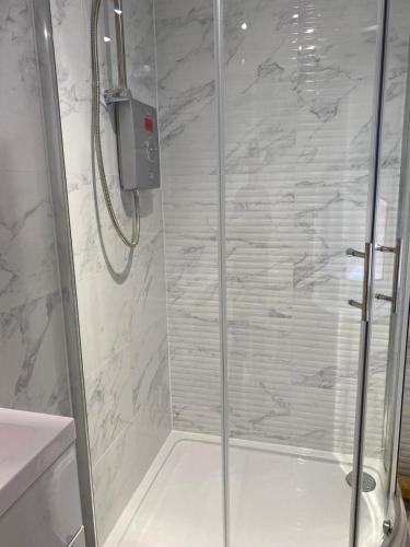 a shower with a glass door in a bathroom at Brownlows Inn Rooms formerly Riley's Rooms in Liverpool