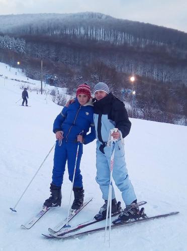 a man and a woman on skis in the snow at Family Green in Sasovka